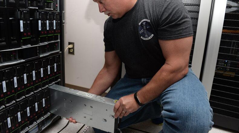 Rich Figliola, 88th Medical Support Squadron system administrator, removes a Hewlett Packard Generation eight blade from a C7000 blade chassis for 88th MDSS at Wright-Patterson Air Force Base Medical Center, July 14. Figliola maintains the 88th MDSS servers for both physical and virtual network systems. (U.S. Air Force photos/Michelle Gigante)