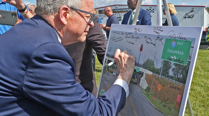 Governor Mike DeWine signs a picture of the completed Interstate 70 and South Limestone Street interchange during a ribbon cutting ceremony celebrating the completion of the lane addition on I-70 between U.S. 68 and State Route 72 Tuesday, July 12, 2022. BILL LACKEY/STAFF