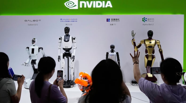 FILE - Visitors give commands to robots at Nvidia's booth during the China International Supply Chain Expo at the China International Exhibition Center in Beijing, China, July 18, 2025. (AP Photo/Mahesh Kumar A., File)