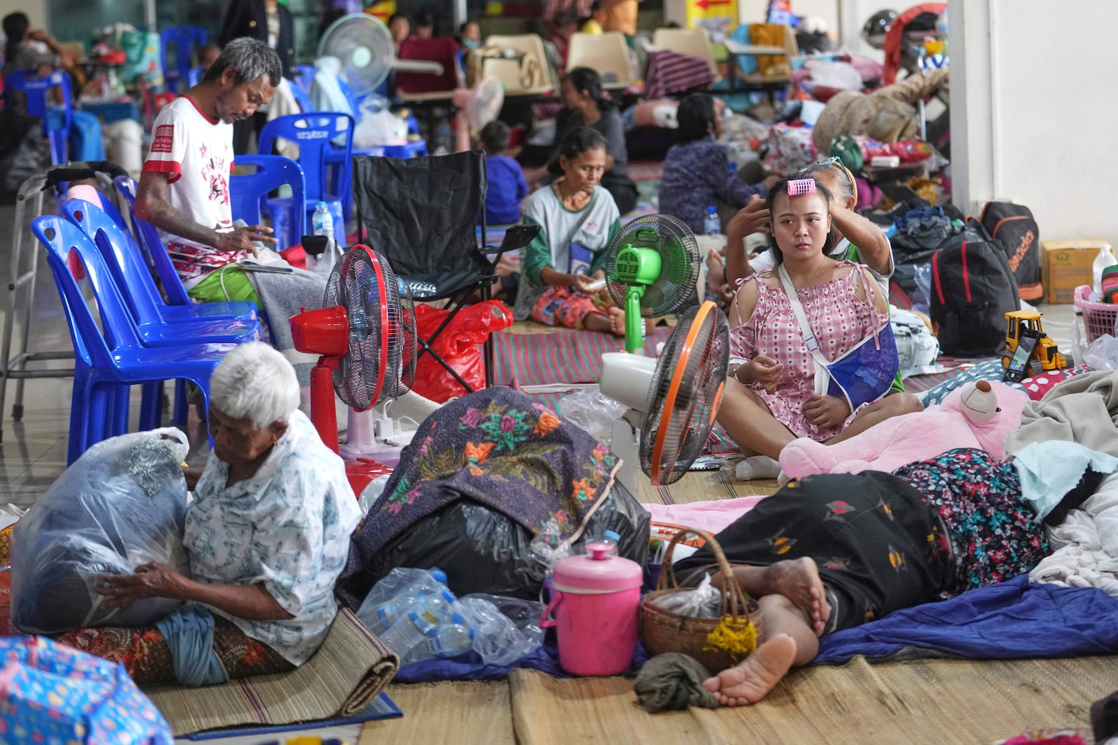 Thai residents who fled homes following clashes between Thai and Cambodian soldiers rest at an evacuation center in Surin province, Thailand, Sunday, July 27, 2025. (AP Photo/Sakchai Lalit)