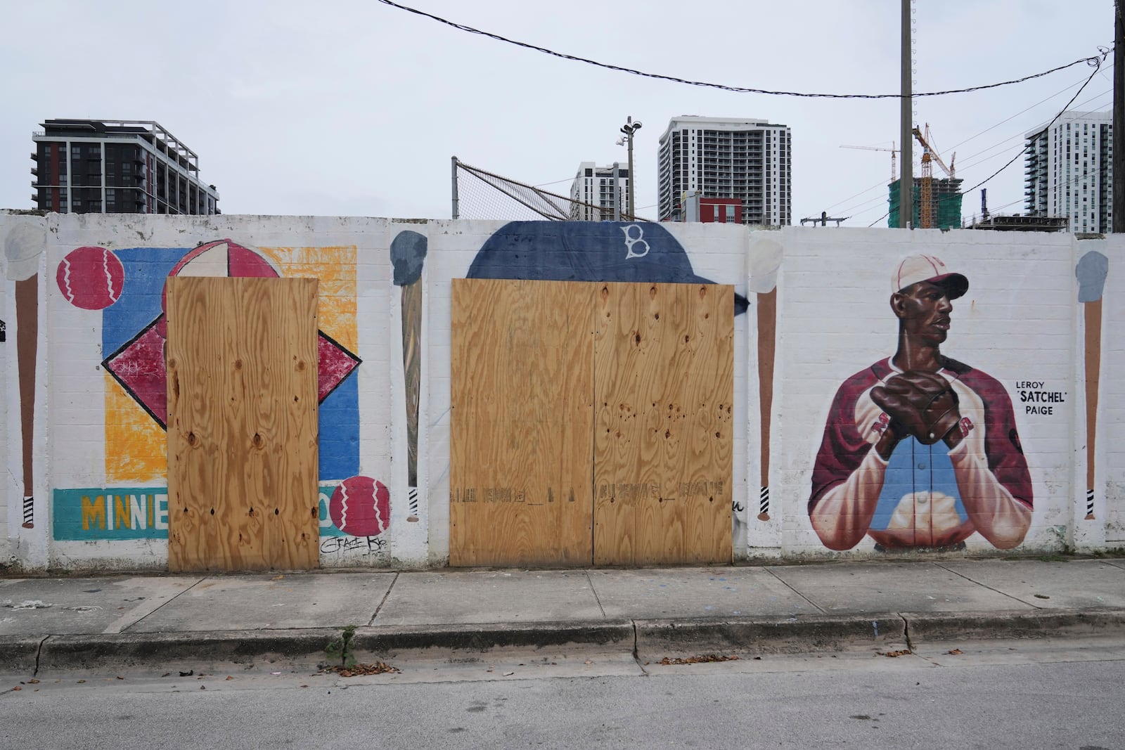 Murals of baseball legends Minnie Miñoso, left, and Jackie Robinson, center, are covered with plywood after being defaced in Miami's Overtown neighborhood, Thursday, June 5, 2025, in Miami. (AP Photo/Lynne Sladky)