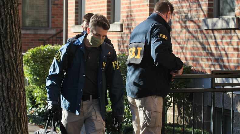 Federal agents bring out boxes after searching a Columbus condo owned by Sam Randazzo, chairman of the Public Utilities Commission of Ohio, on Monday, Nov. 16, 2020, in Columbus. David Jablonski/Staff