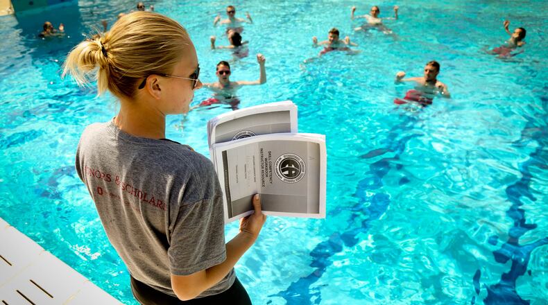 Head Lifeguard Morgan Avers holds pages of a checklist as she monitors lifeguards treading water as they are being trained at the Miamisburg pool in preparation for the summer swimming season in 2015. JIM WITMER/STAFF