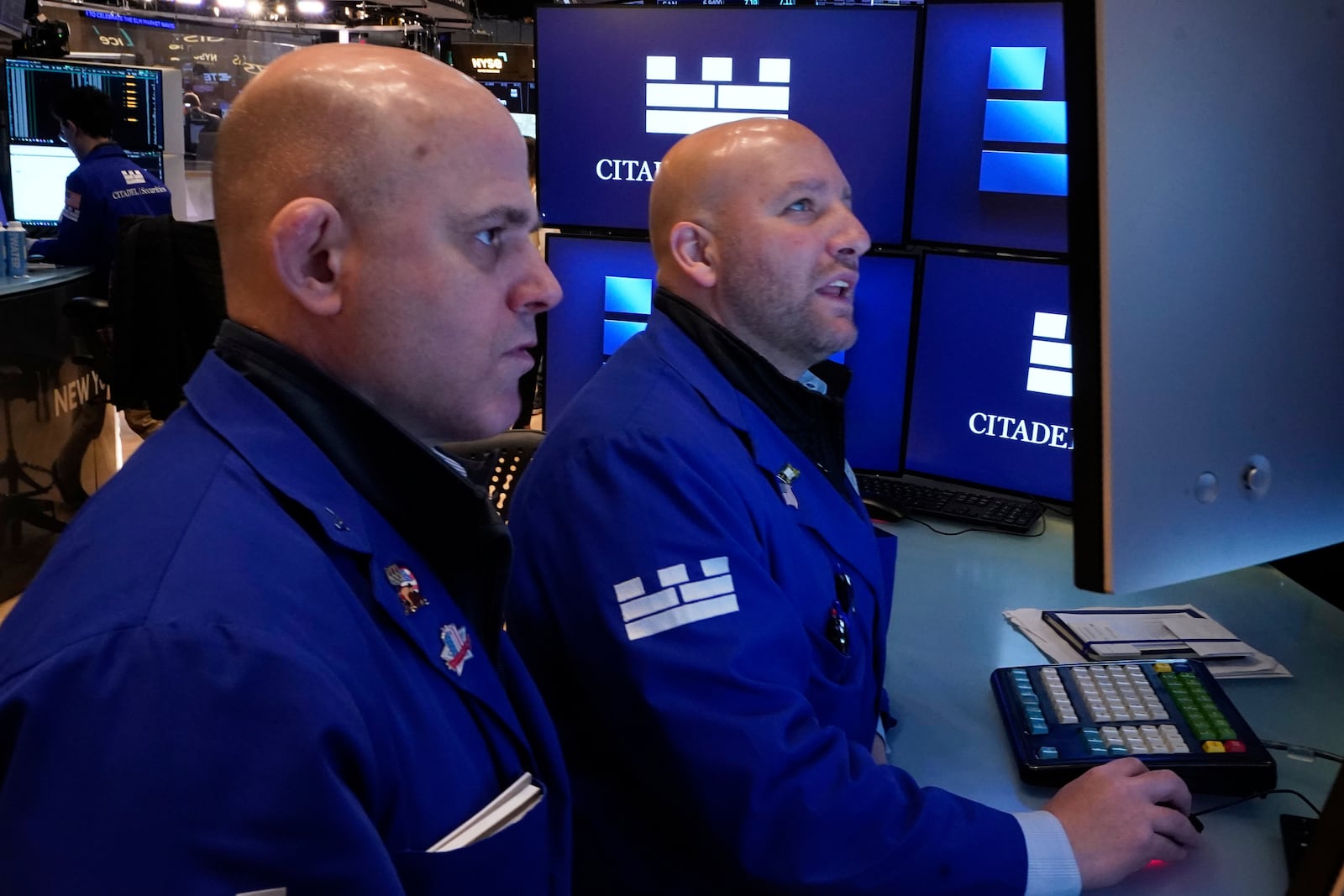 Specialists Mark Fitzgerald, left, and John Parisi confer on the floor of the New York Stock Exchange, Wednesday, April 23, 2025. (AP Photo/Richard Drew)