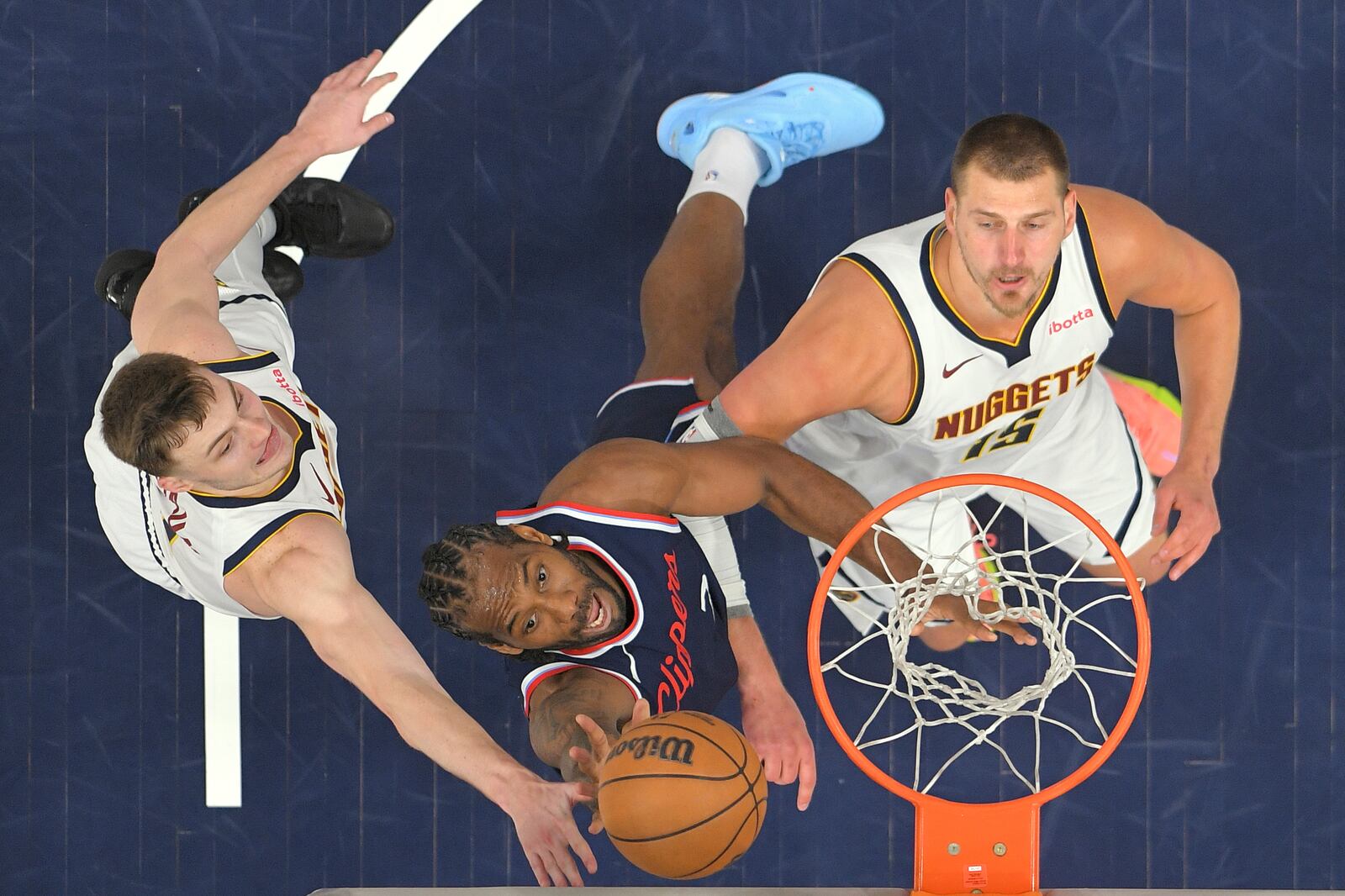 Los Angeles Clippers forward Kawhi Leonard, center, shoots as tguard Christian Braun, left, and center Nikola Jokic defends during the first half in Game 4 of an NBA basketball first-round playoff series Saturday, April 26, 2025, in Inglewood, Calif. (AP Photo/Mark J. Terrill)