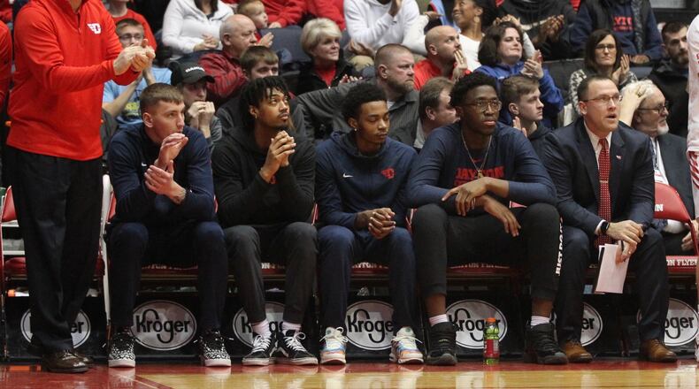 Dayton players (left to right) Chase Johnson, Ibi Watson, Rodney Chatman and Jordy Tshimanga sit on the bench, along with coach Andy Farrell, far right, against Massachusetts on Sunday, Jan. 13, 2019, at UD Arena. David Jablonski/Staff