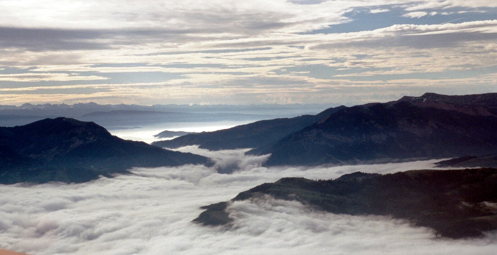 Fog fills the valleys near Jackson Hole, Wyoming just after sunrise. - 1997
