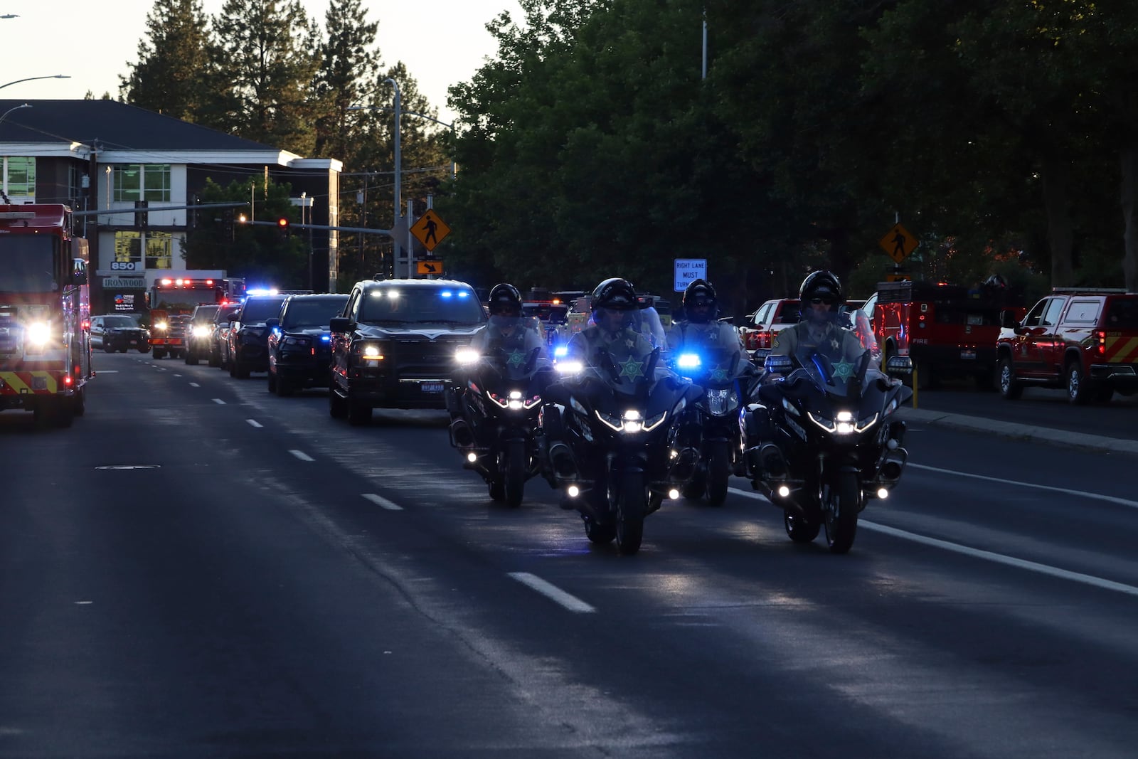 A procession from Kootenai Health headed to Spokane after a few firefighters were killed Sunday, June 29, 2025, when they were ambushed by sniper fire while responding to a blaze in a northern Idaho mountain community, in Coeur d’Alene, Idaho. (Bill Buley/Coeur D'Alene Press via AP)/