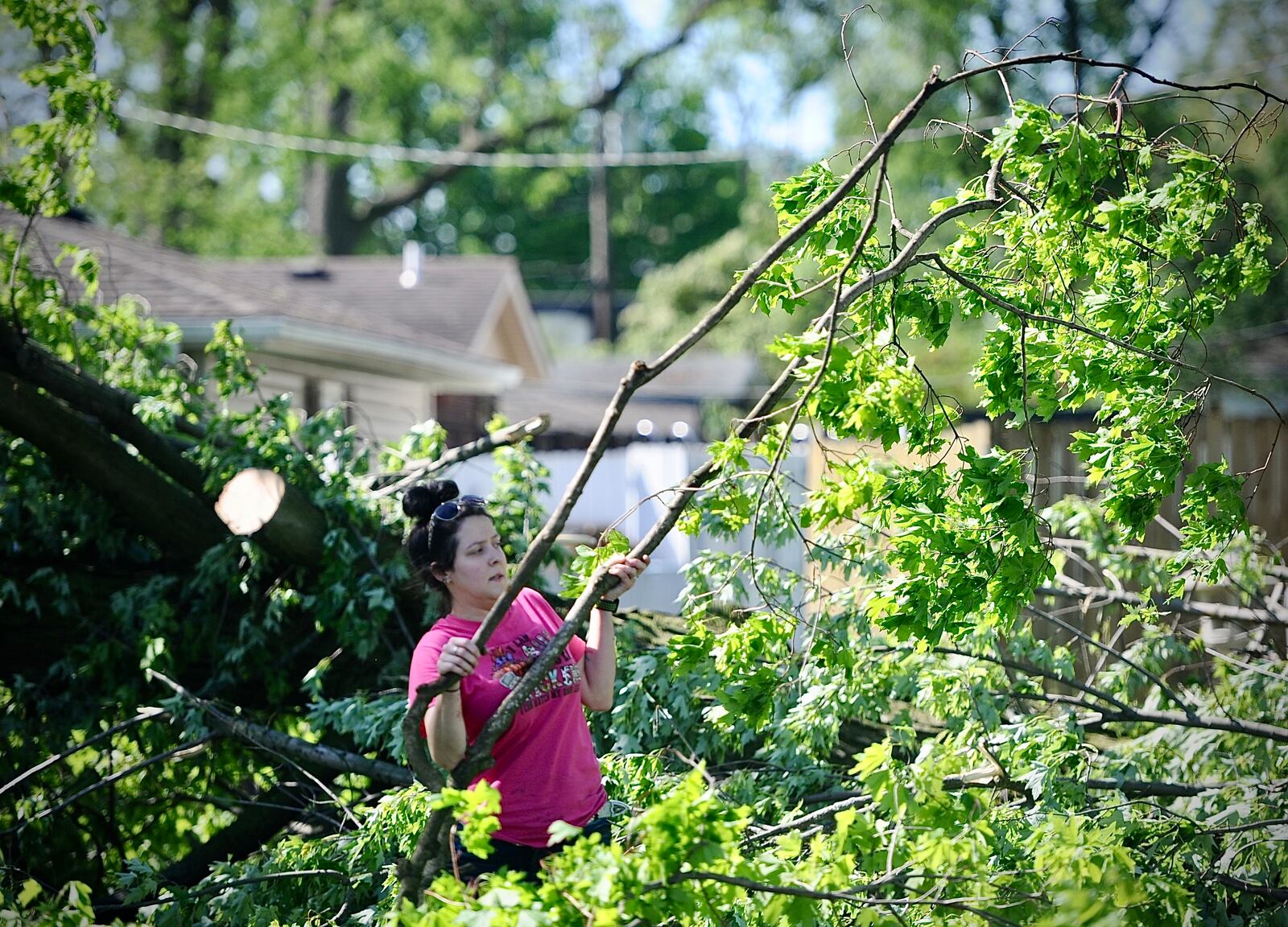 Andrea Arthur helps out a disabled friend by removing tree branches out of his yard in Greenville, Wednesday, May 8, 2024. MARSHALL GORBY \STAFF