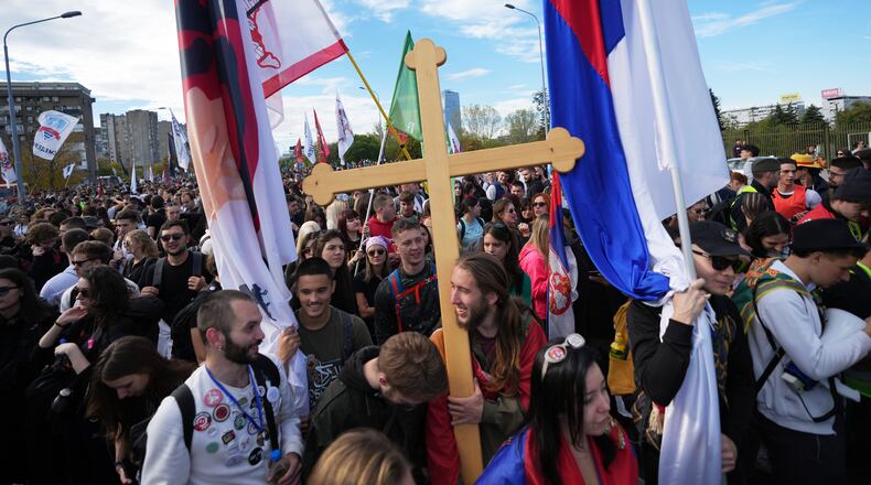 People gather, among them students, to walk on the street towards the northern city of Novi Sad, for a huge rally on Nov. 1 marking the first anniversary of a train station disaster that killed 16 people, in Belgrade, Serbia, Thursday, Oct. 30, 2025. (AP Photo/Darko Vojinovic)