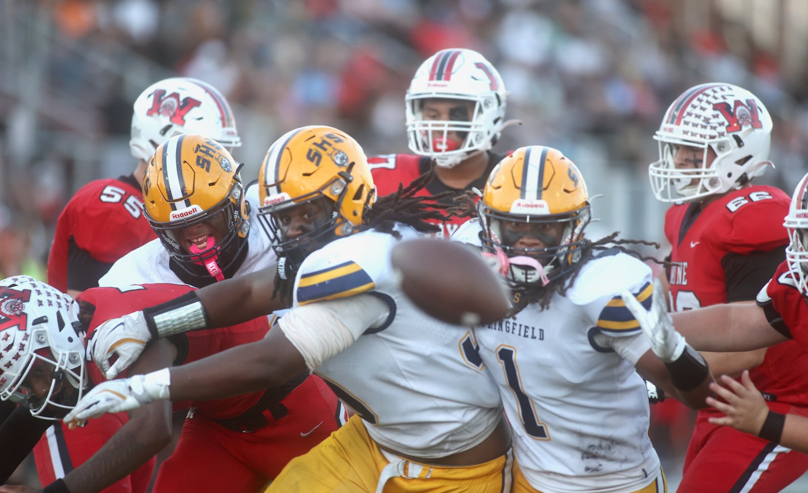 Springfield defensive players and Wayne offensive players eye a loose football in the first half on Friday, Oct. 3, 2025, at Heidkamp Stadium in Huber Heights. The play was rule dead, so there was no fumble. David Jablonski/Staff