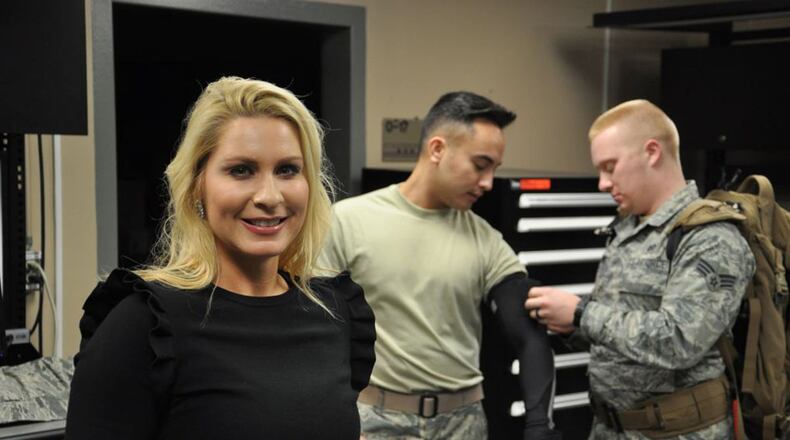 Sabra Tomb, a technology transfer specialist from the 711th Human Performance Wing’s Office of Research & Technology Applications, visits the Battlefield Air Target Man-Aided Knowledge, or BATMAN Lab, at the 711th HPW while 2nd Lt. David Sardo, a design and test engineer at the 711 HPW and lead developer on the Flashing Indicator of Swimmers’ Health system, and Senior Airman Bradley Nimmo, an Engineering Technician with the 711 HPW prepare to showcase a FISH prototype. The FISH system measures both oxygen saturation and heart rate of swimmers and has been in development since 2016. (U.S. Air Force photo/2nd Lt. Weston Woodward)