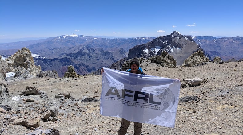 Air Force Research Laboratory researcher Kevin D. Schmidt unfurls an AFRL flag on Mount Aconcagua in South America. CONTRIBUTED