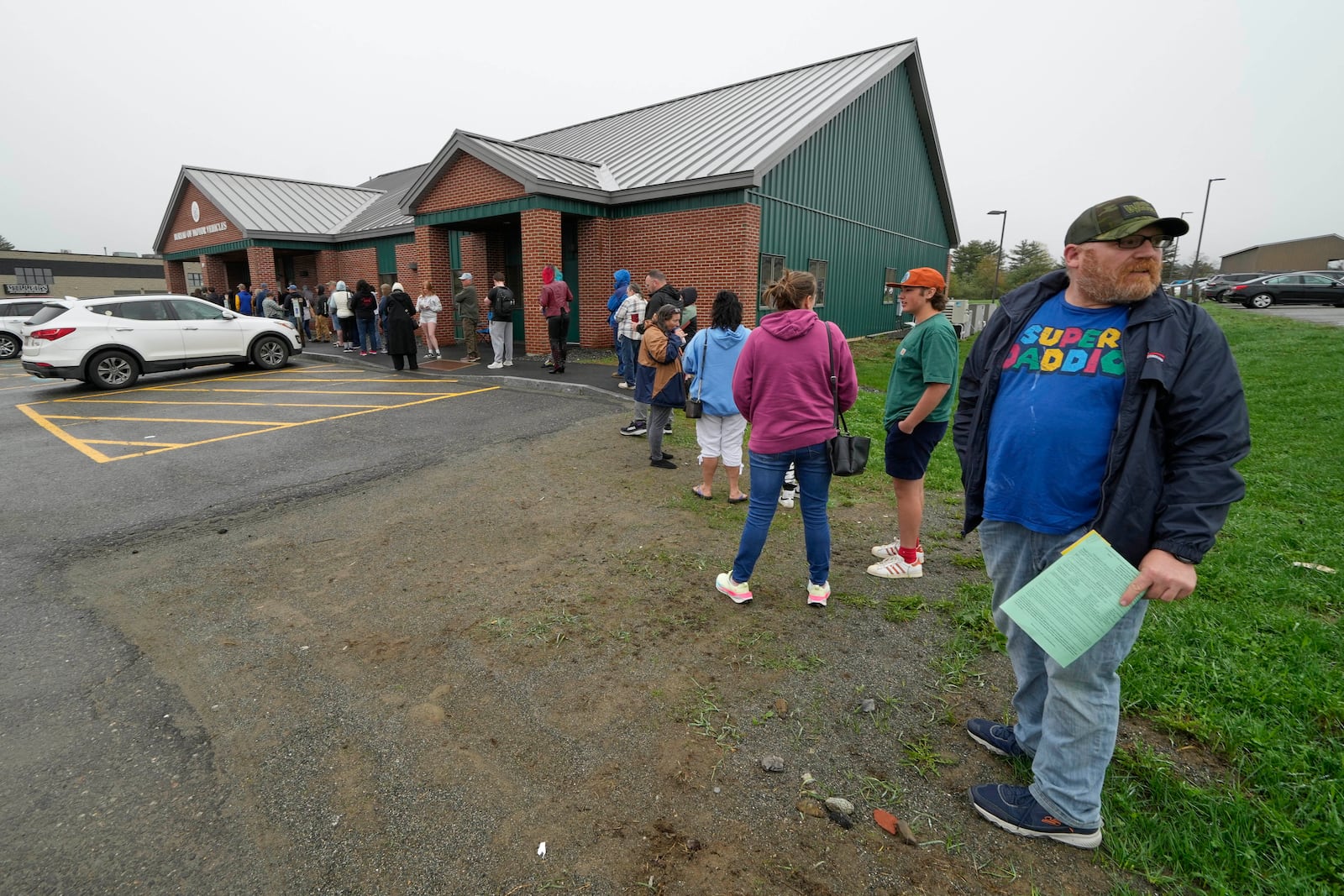 Matthew Nason of Vassalboro, Maine, who needed to file forms for his motorcycle, waits at the end of a long line at the Bureau of Motor Vehicles where many residents are applying for Real ID, Wednesday, May 7, 2025, in Augusta, Maine. (AP Photo/Robert F. Bukaty)