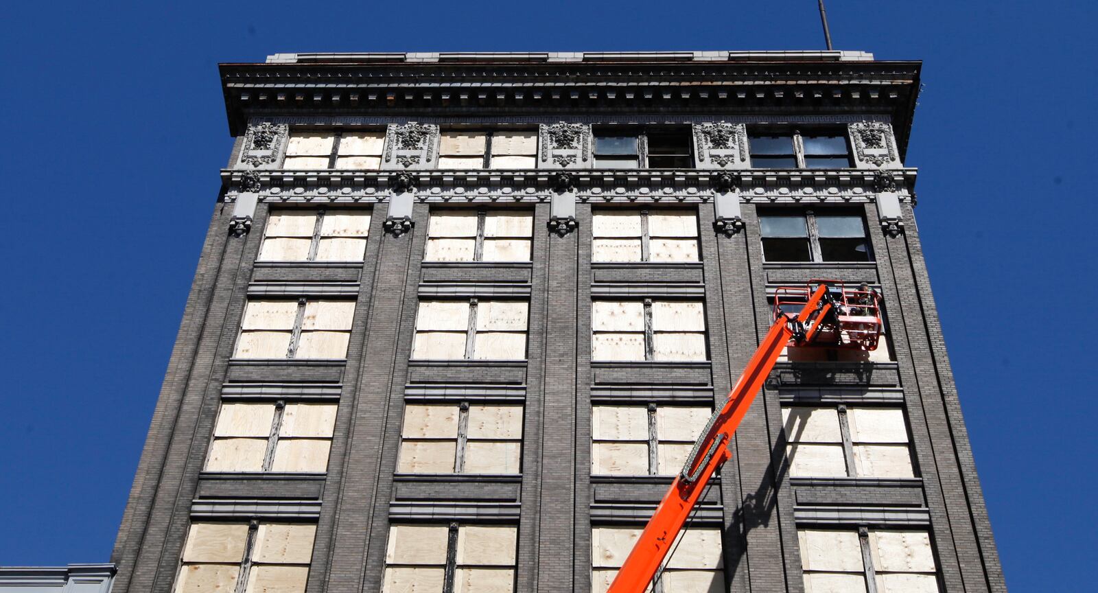 Workers board up windows at the Arcade complex's Commercial Building on Monday, April 22. CHRIS STEWART / STAFF