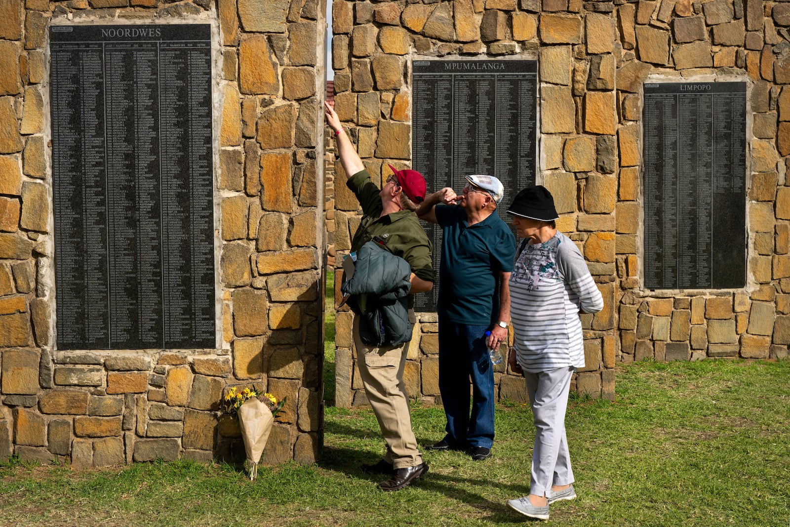 Visitors at the Nampo agricultural fair, one of the largest in the southern hemisphere, check names on the wall of remembrance, a tribute to farmers killed since 1961, near Bothaville, South Africa, May 15, 2025. (AP Photo/Jerome Delay)
