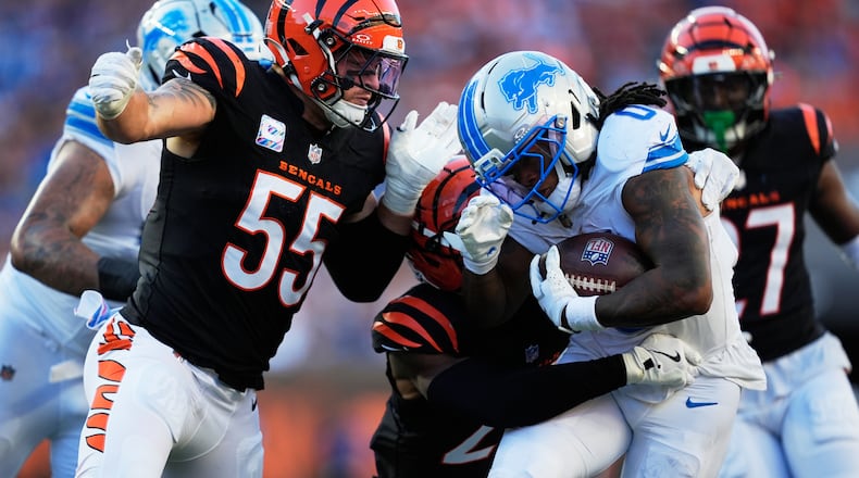 Detroit Lions running back Jahmyr Gibbs (0) runs through Cincinnati Bengals linebacker Logan Wilson (55) for a 20-yard touchdown reception during the second half of an NFL football game Sunday, Oct. 5, 2025, in Cincinnati. (AP Photo/Carolyn Kaster)