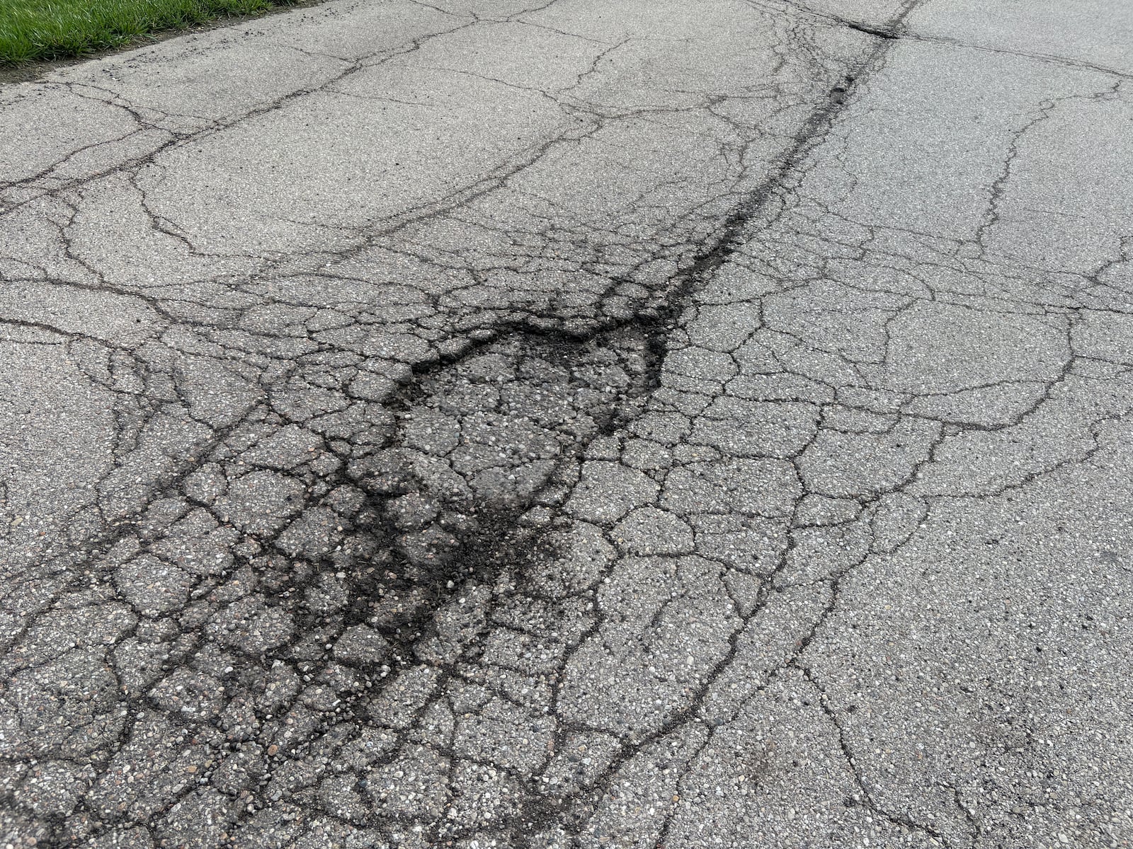 Hemingway Drive in Auteur Estates off Ohio 48 between East Lytle 5 Points Road and Ohio 73 has a pothole and a web of cracks near the entrance to the subdivision of custom houses. JEN BALDUF/STAFF
