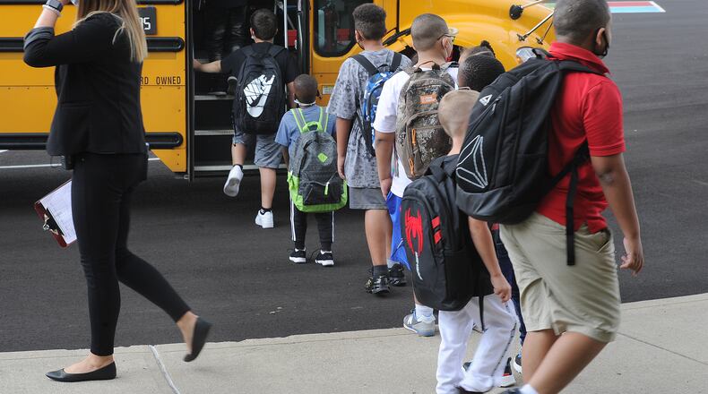Students at Eastmont elementary in Dayton wait to board the bus at the end of the first day of school on Wednesday Aug. 18, 2021. MARSHALL GORBY\STAFF