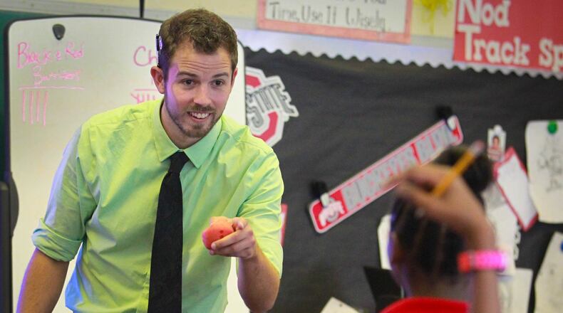Charlie Bullworks with sixth graders on a social studies exercise at Dayton Charter school DECA Prep. JIM WITMER / STAFF