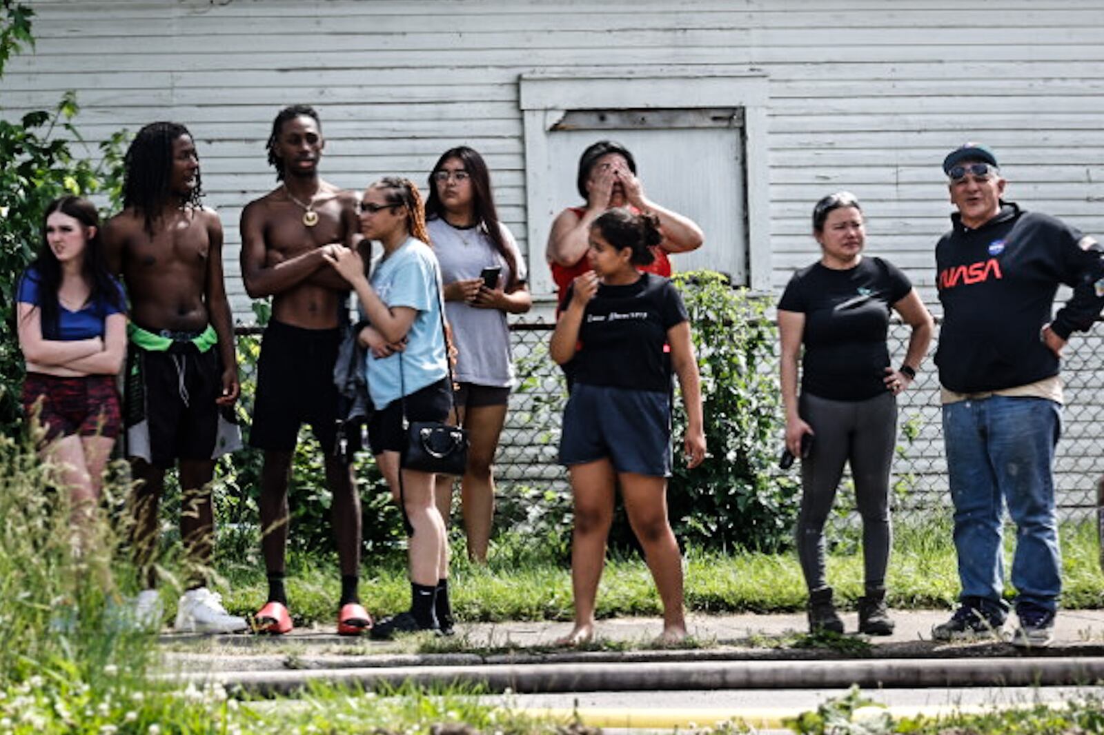Neighbors look on as crews fight a blaze in a pile of tires on Leonhard Street in Dayton May 20, 2024. JIM NOELKER/STAFF