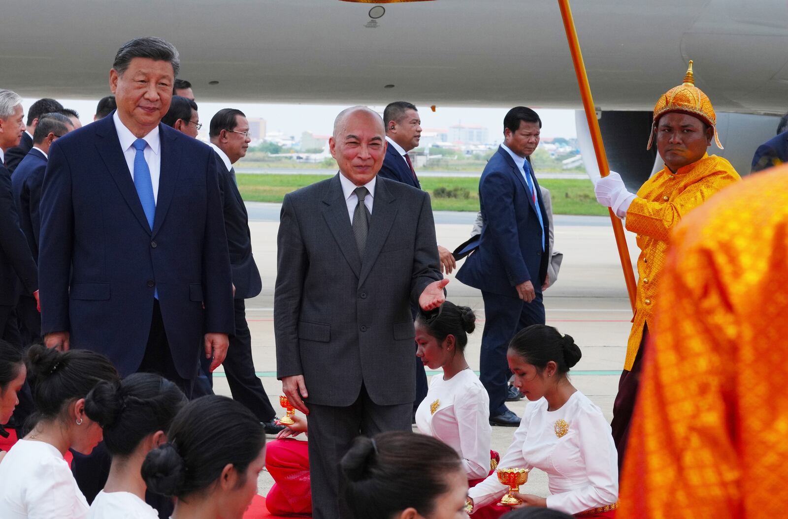 In this photo released by Agence Kampuchea Press (AKP), Cambodia's King Norodom Sihamoni, center, and Chinese President Xi Jingping, left, walk together during a welcome ceremony at Phnom Penh International Airport in Phnom Penh, Cambodia, Thursday, April 17, 2025. (AKP via AP)