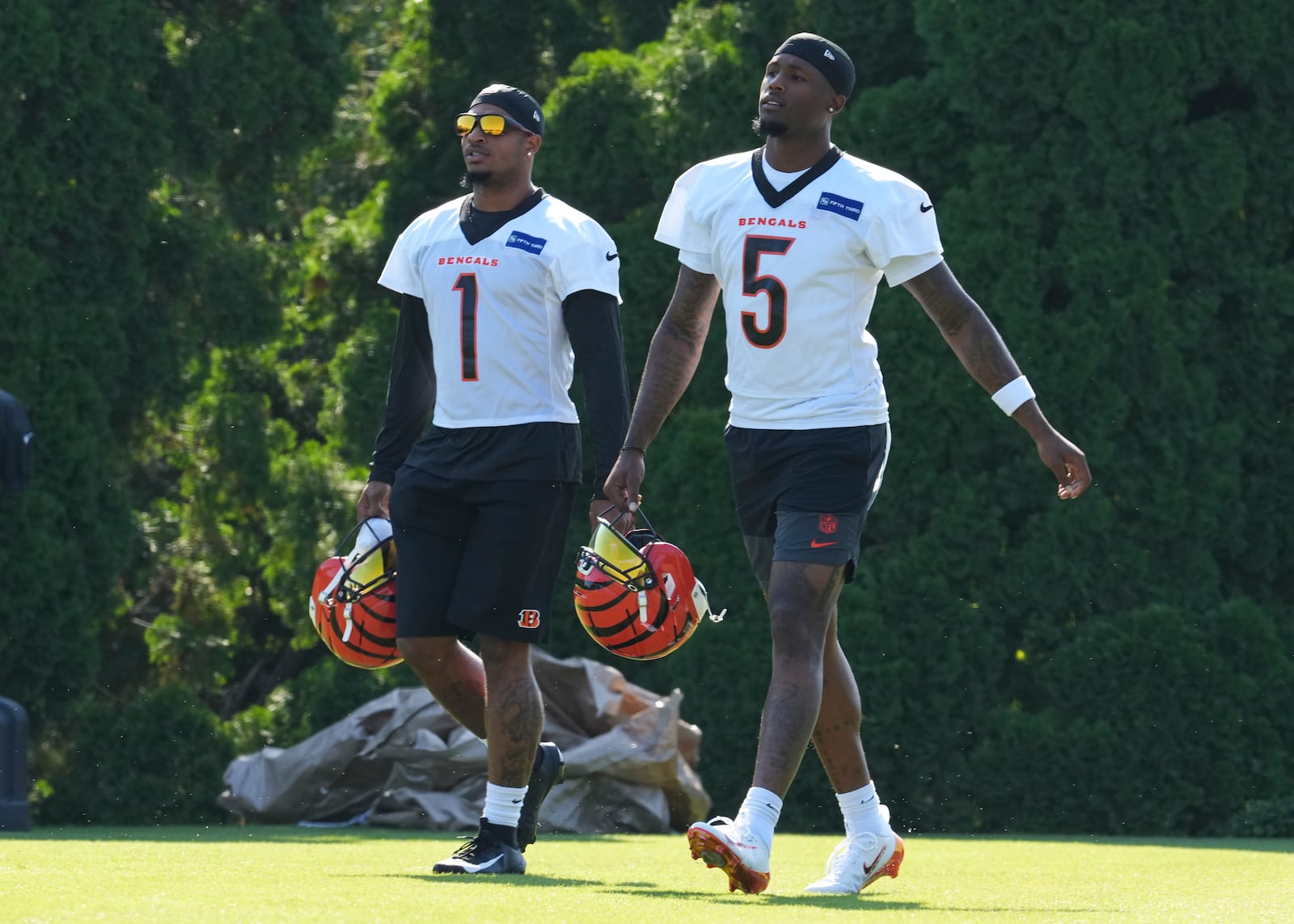 Cincinnati Bengals' Ja'Marr Chase (1) and Tee Higgins (5) walk to the field before practice at the team's NFL football training camp, Wednesday, July 23, 2025, in Cincinnati. (AP Photo/Jeff Dean)