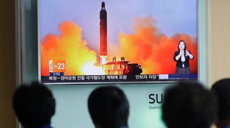 People watch a TV news channel airing an image of North Korea's ballistic missile launch published Thursday in North Korea's Rodong Sinmun newspaper at the Seoul Railway Station in Seoul, South Korea, Thursday, June 23, 2016. North Korean leader Kim Jong Un on Thursday trumpeted the success of a powerful new midrange ballistic missile test that state media says propelled one of the weapons more than 1,400 kilometers (870 miles), saying it would allow strikes on U.S. forces throughout the region. (AP Photo/Ahn Young-joon)