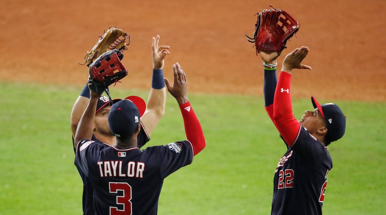 HOUSTON, TEXAS - OCTOBER 23:  Juan Soto #22, Michael A. Taylor #3 and Gerardo Parra #88 of the Washington Nationals celebrate their 12-3 win over the Houston Astros in Game Two of the 2019 World Series at Minute Maid Park on October 23, 2019 in Houston, Texas. (Photo by Tim Warner/Getty Images)