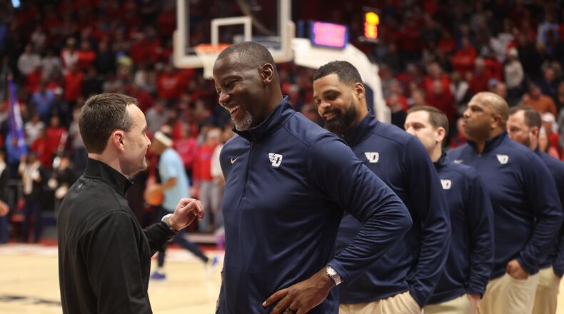 Dayton's Anthony Grant, center, talks to Rhode Island's Archie Miller before the game on Saturday, Jan. 20, 2024, at UD Arena. David Jablonski/Staff