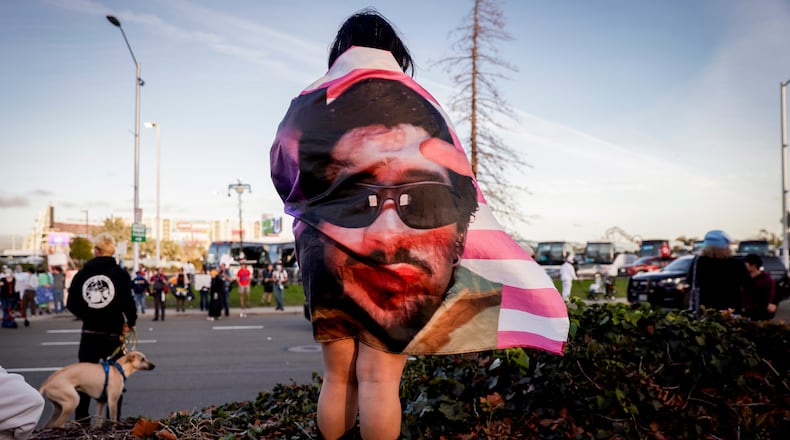 Kenia Medal wears a Bad Bunny flag while waiting to watch the halftime show outside Levi's Stadium during the NFL Super Bowl 60 football game between the Seattle Seahawks and the New England Patriots in Santa Clara, Calif., Sunday, Feb. 8, 2026. (Brontë Wittpenn/San Francisco Chronicle via AP)