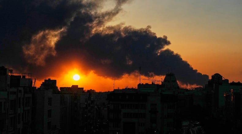 The sun sets behind a plume of smoke rising after a U.S.–Israeli military strike in Tehran, Iran, Tuesday, March 3, 2026. (AP Photo/Vahid Salemi)