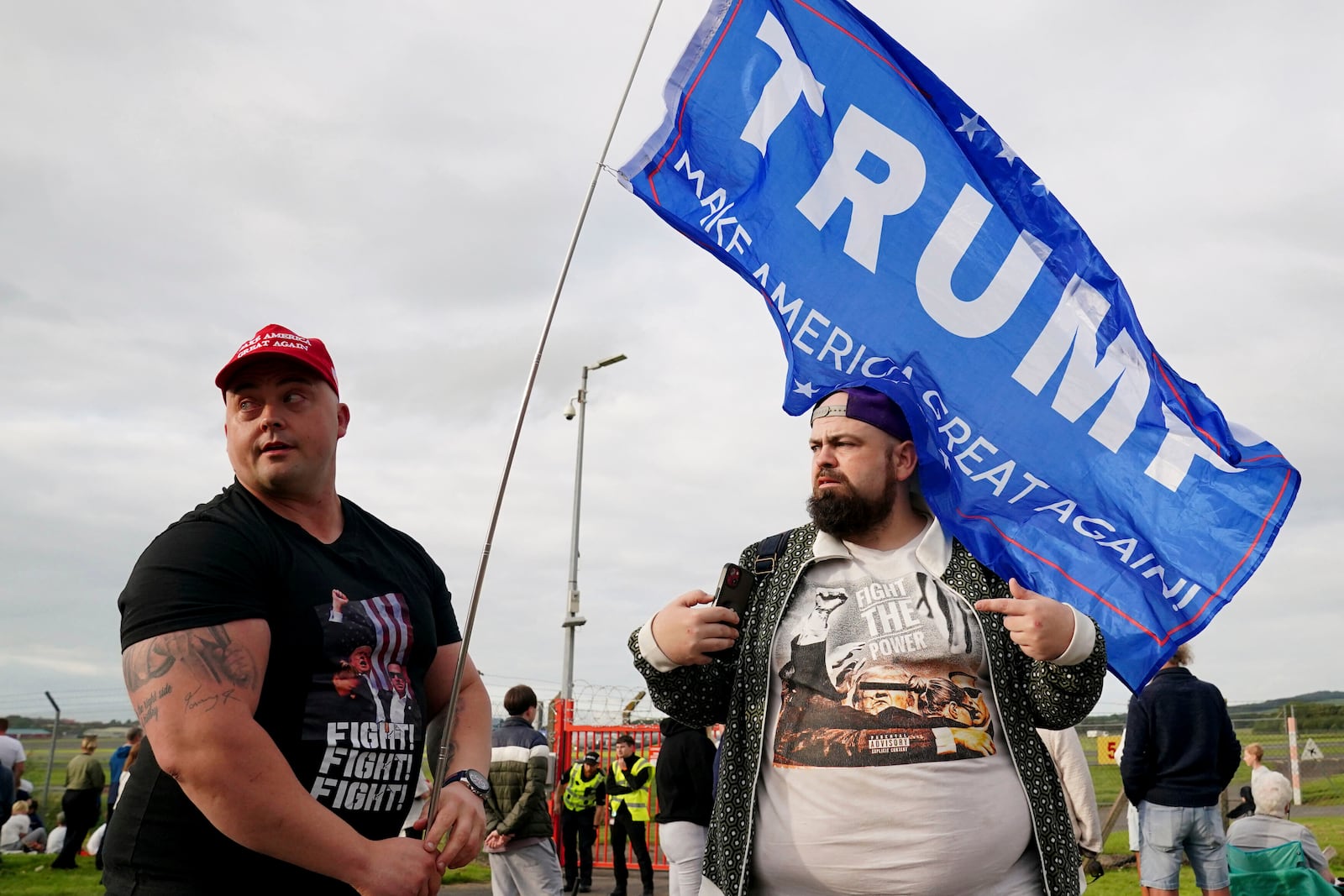 People gather outside the airport in Prestwick, South Ayrshire, Scotland, on Friday, July 25, 2025, ahead of the arrival of U.S. President Donald Trump. (Jane Barlow/PA via AP)