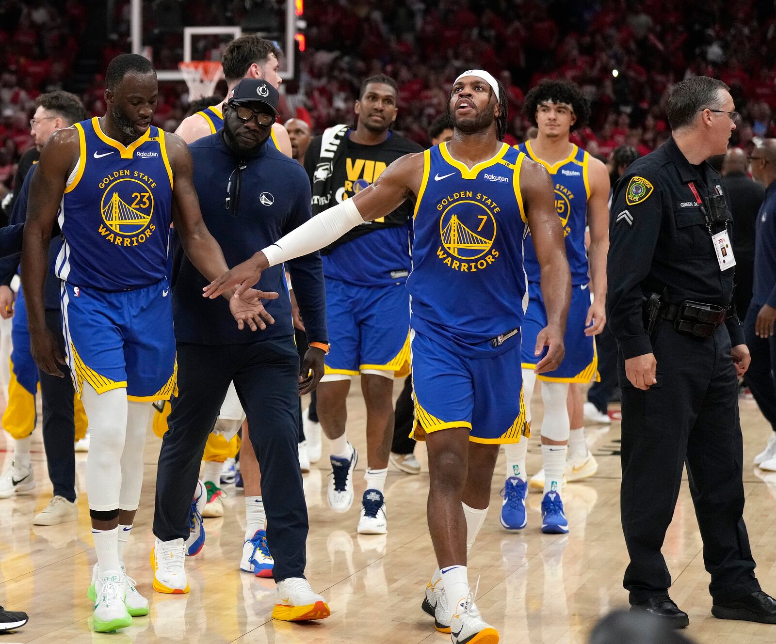 Golden State Warriors forward Draymond Green (23) is escorted back to the bench by a coach and guard Buddy Hield (7) after a brief scuffle with the Houston Rockets during the second half of Game 2 of an NBA basketball first-round playoff series against the Houston Rockets in Houston, Wednesday, April 23, 2025. (AP Photo/Karen Warren)