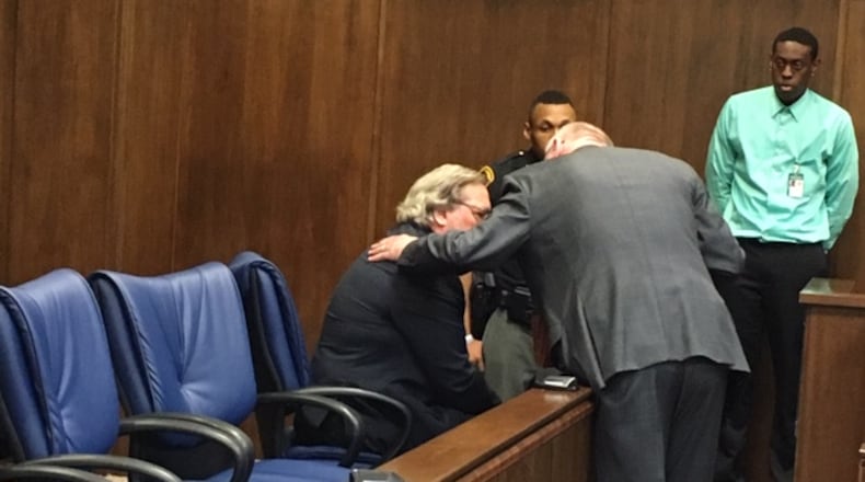 John Gregory Schmidt, seated, spoke with his attorney, Steve Pierson, for a moment after his sentencing in Montgomery County Common Pleas Court, before he was taken away to begin serving a five-year prison sentence. THOMAS GNAU/STAFF