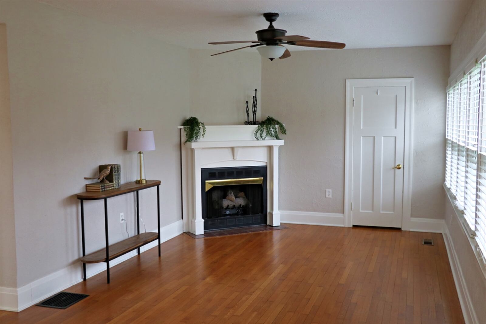 Tucked into one corner of the living room is a decorative fireplace with wood mantel. 