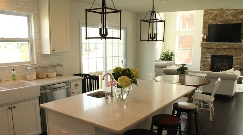 Marbled white quartz tops the kitchen’s long center island and all the surrounding counters in the U-shaped work space.