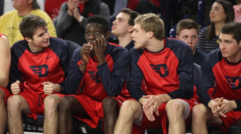 Dayton players (left to right: Joey Gruden, Jeremiah Bonsu, Michael Schwieterman and Jack Westerfield) watch from the bench during a game against Richmond on Tuesday, March 1, 2016, at the Robins Center in Richmond, Va. David Jablonski/Staff