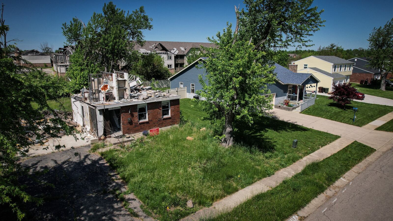 Homeowners struggled following the 2019 Memorial Day tornadoes. On Trotwood's Greenbrook Drive in May 2022, beautifully rehabbed houses are neighbors to a destroyed, vacant home. JIM NOELKER/STAFF