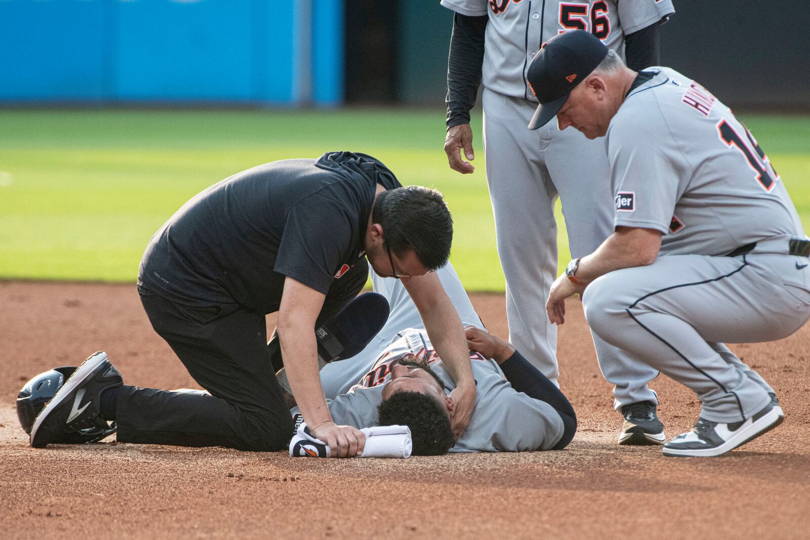 Detroit Tigers' Gleyber Torres, center bottom, is tended to after an injury at second base as manager A.J. Hinch, right, looks on during the first inning of a baseball game against the Cleveland Guardians, Saturday, July 5, 2025, in Cleveland. Torres was taken out of the game. (AP Photo/Phil Long)