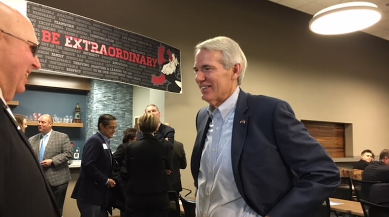 U.S. Sen. Rob Portman, center, talks with a guest at a Dayton Area Chamber of Commerce briefing Friday morning at Heidelberg Distributing’s Moraine distribution center. THOMAS GNAU/STAFF