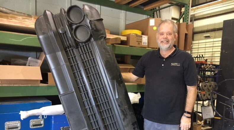 Dan McLaughlin, partner in West Carrollton’s Scenic Solutions, with a mockup of the front of a vintage Cadillac Eldorado. The company has built a $3 million-a-year business primarily building entertainment sets for clients. THOMAS GNAU/STAFF