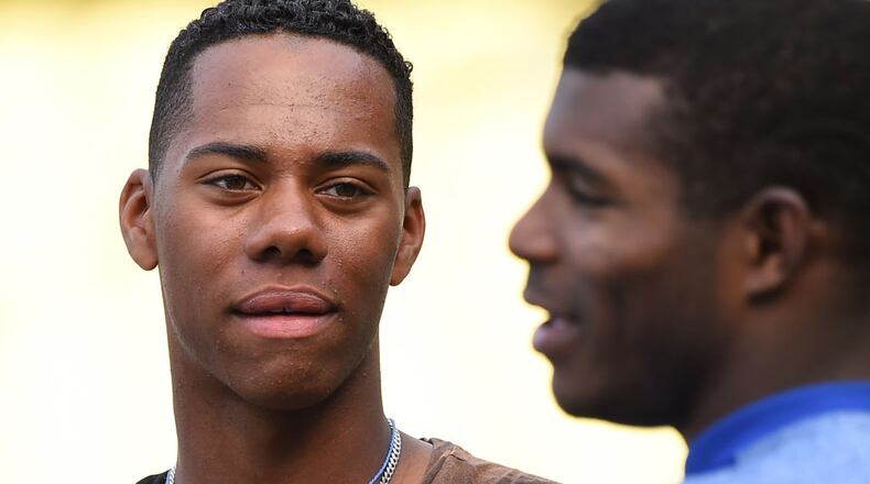 LOS ANGELES, CA - APRIL 28: High School baseball player Hunter Greene, from Stevenson Ranch, CA, the possible first overall pick in the 2017 MLB draft, talks with Yasiel Puig #66 of the Los Angeles Dodgers during batting practice before the game against the Philadelphia Phillies at Dodger Stadium on April 28, 2017 in Los Angeles, California. (Photo by Jayne Kamin-Oncea/Getty Images)