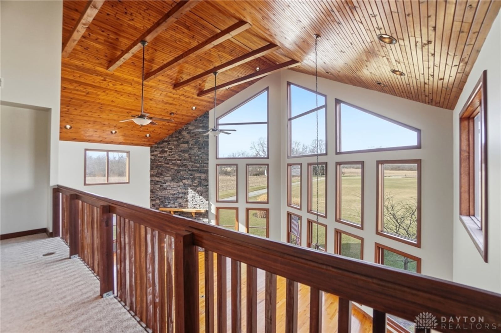 the second floor loft overlooks the great room and has neutral carpeting, a beamed ceiling and wood railings. CONTRIBUTED