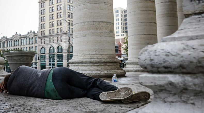 An unsheltered man sleeps on the Main Street side of the Courthouse Square steps Wednesday September 27, 2023. JIM NOELKER/STAFF