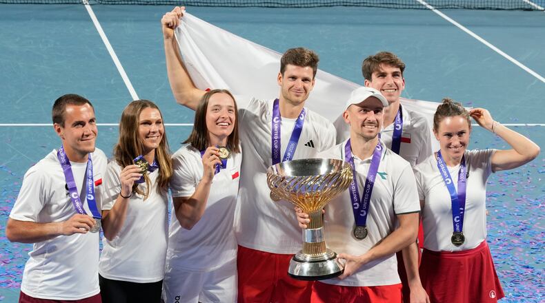 Teammembers from Poland celebrate with their trophy after defeating Switzerland in the final at the United Cup tennis tournament in Sydney, Monday, Jan. 12, 2026. (AP Photo/Rick Rycroft)