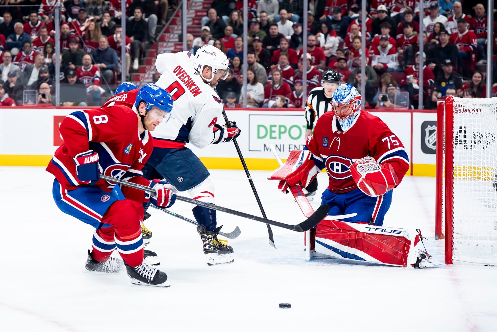 Washington Capitals' Alex Ovechkin, center, attempts to score against Montreal Canadiens goaltender Jakub Dobes (75) while defended by Canadiens' Mike Matheson, left, during the second period of Game 3 of a first-round NHL hockey playoff series in Montreal Friday, April 25, 2025. (Christopher Katsarov/The Canadian Press via AP)
