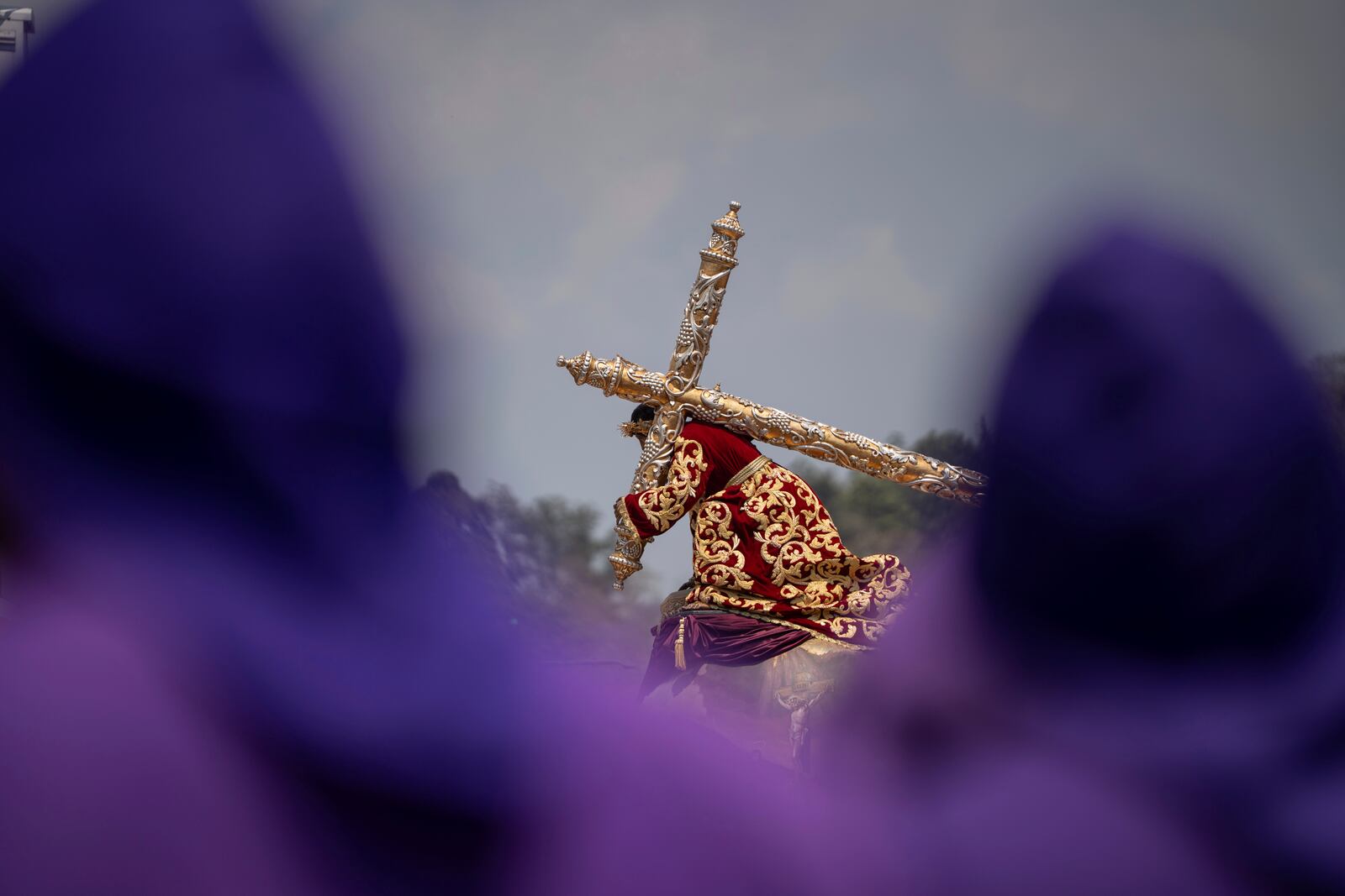 Faithful carry a wooden platform with a statue of Jesus of Nazareth, wearing a tunic created by weavers at the Maria Auxiliadora embroidery workshop, during a Lenten season procession in Antigua, Guatemala, Sunday, April 6, 2025. (AP Photo/Santiago Billy)