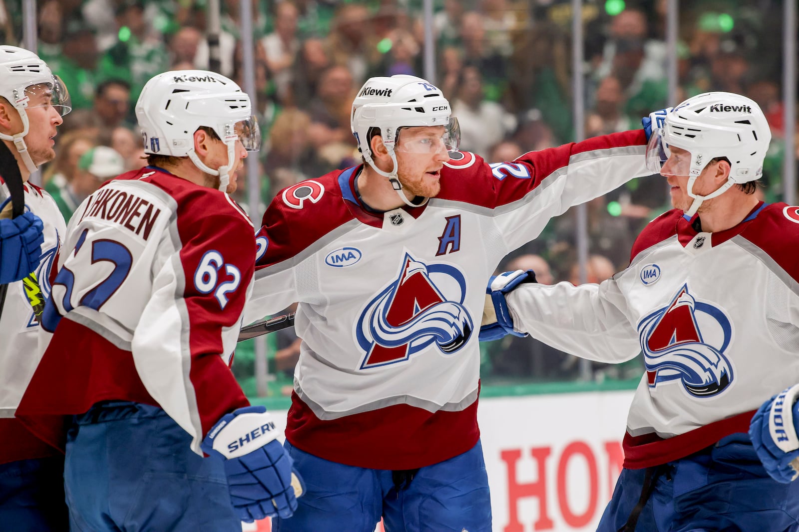 Colorado Avalanche's Artturi Lehkonen (62), Nathan MacKinnon (29) and Josh Manson, right, celebrate after Lehkonen's goal during the second period of Game 5 of a first-round NHL hockey playoff series against the Dallas Stars in Dallas, Monday, April 28, 2025. (AP Photo/Gareth Patterson)