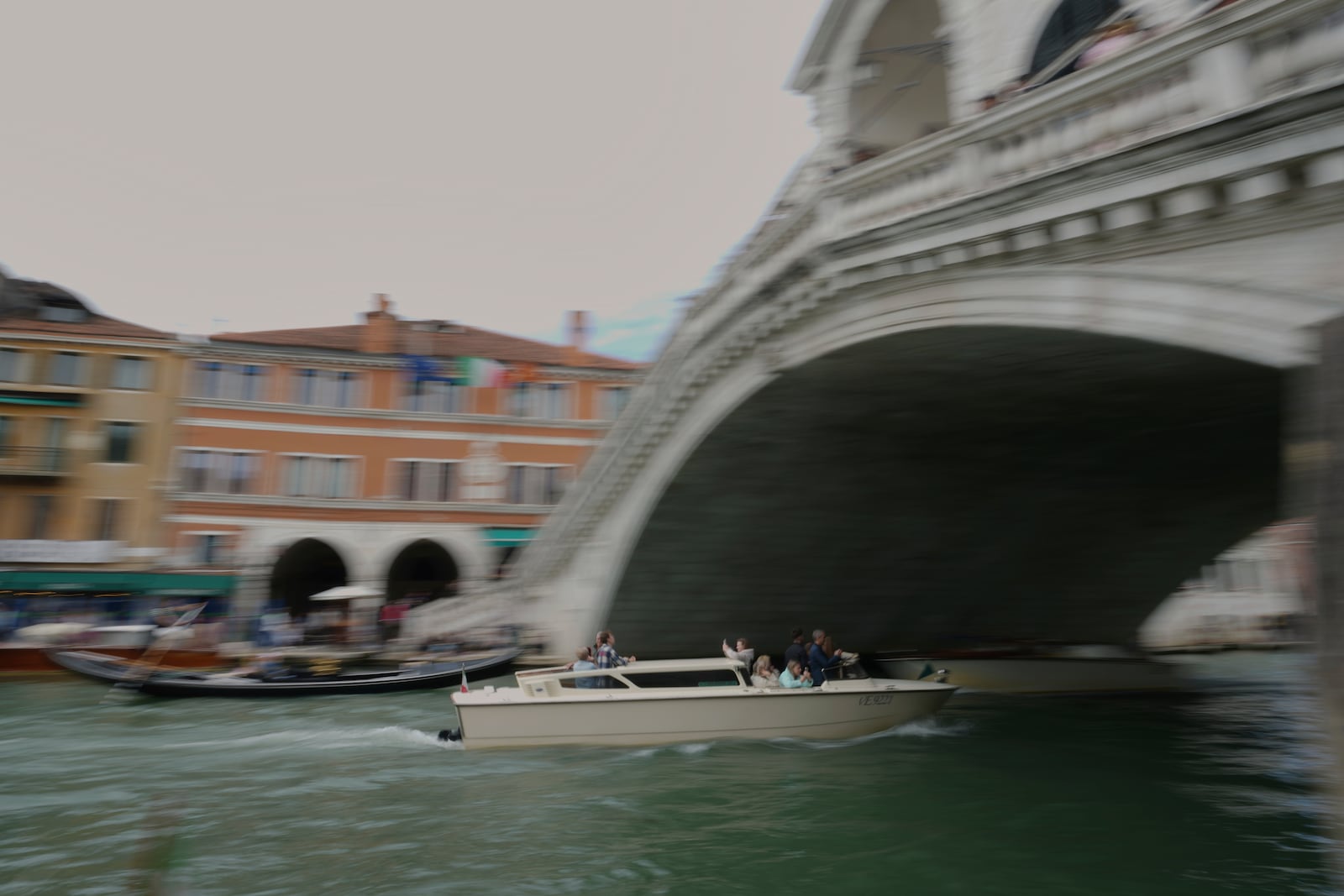 A taxi sails under the Rialto Bridge "Ponte di Rialto" in Venice, Italy, Friday, April 18, 2025, Venice on Friday launches for a second year a pilot program to charge day-trippers an entrance fee. (AP Photo/Antonio Calanni)